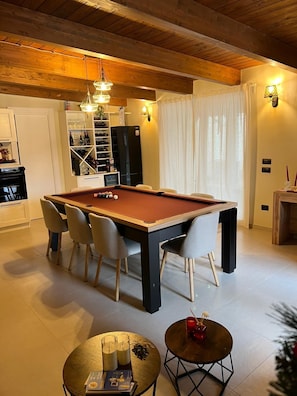 A modern living room with a pool table, comfortable seating, and a cozy fireplace. - Cozy and intimate retreat to relax and indulge in quality time. (Lanzara)