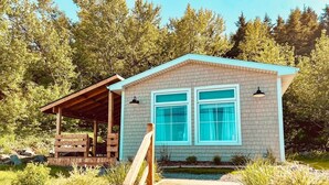 Ein kleines, eingeschossiges Gebäude mit einer Veranda und einer Holztreppe, die zum Eingang führt.