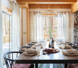 Ein Esszimmer aus Holz mit einem großen Tisch, gedeckt für sechs Personen, umgeben von Stühlen.