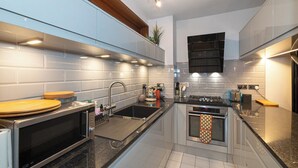 Una cocina moderna con horno empotrado, microondas y lavabo.