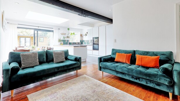Un salon moderne avec deux canapés verts et une table basse en bois.
