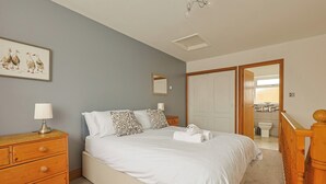 Ein Schlafzimmer mit einem Bett, einem Nachttisch aus Holz und einem Spiegel.