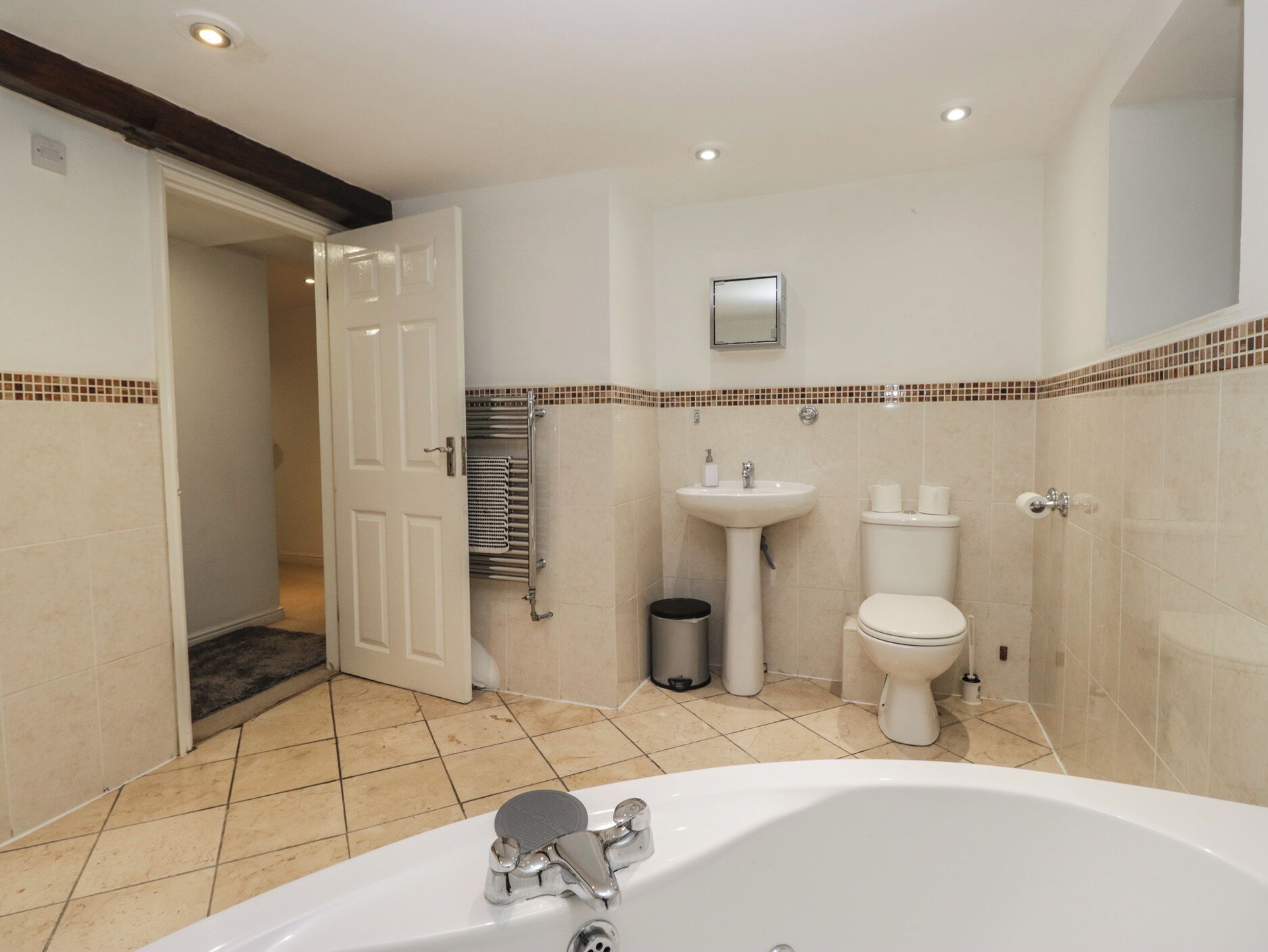 A bathroom with a bathtub, toilet, sink, and towel rack.