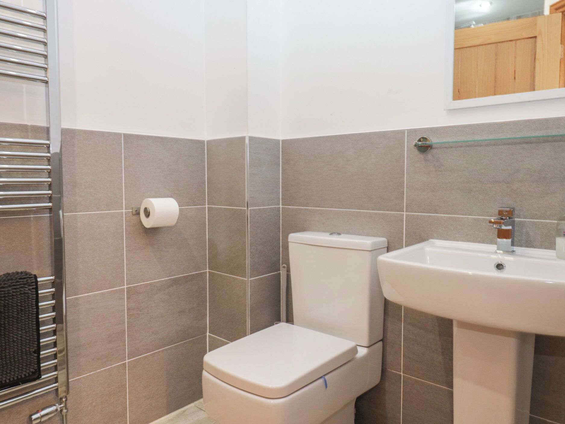 A bathroom with a toilet, sink, and towel rack.