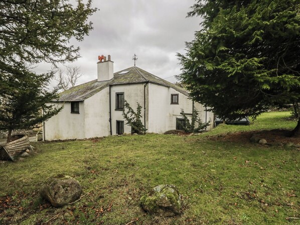 A white house with a sloped roof, a chimney, and a small porch area. - Birkbank Farm (Cockermouth)