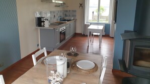 Eine moderne Küche mit grauen Schränken, einem eingebauten Backofen und einem Fenster mit Blick auf einen Garten.