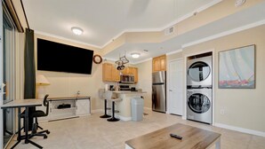 Una cocina moderna con comedor, horno empotrado, refrigerador y lavadora.