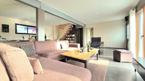 A modern living room with a sofa, a coffee table, and a bookshelf. - Spacious family home near Vannes, Terémer (Saint-Nolff)