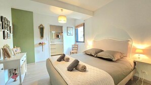 A bedroom with a bed, bedside table, and a chair. There is a mirror on the wall and a picture frame on the dresser. - Spacious family home near Vannes, Terémer (Saint-Nolff)
