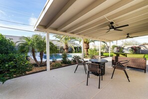 A covered patio area with a pool, outdoor furniture, and palm trees. - Shop, Swim & Explore: Updated Phoenix Home! (Phoenix)