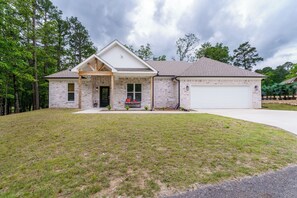 A single-story brick house with a front porch, a garage, and a well-maintained lawn. - Steps to Fairway: Hot Springs Village Golf Retreat (Hot Springs Village)