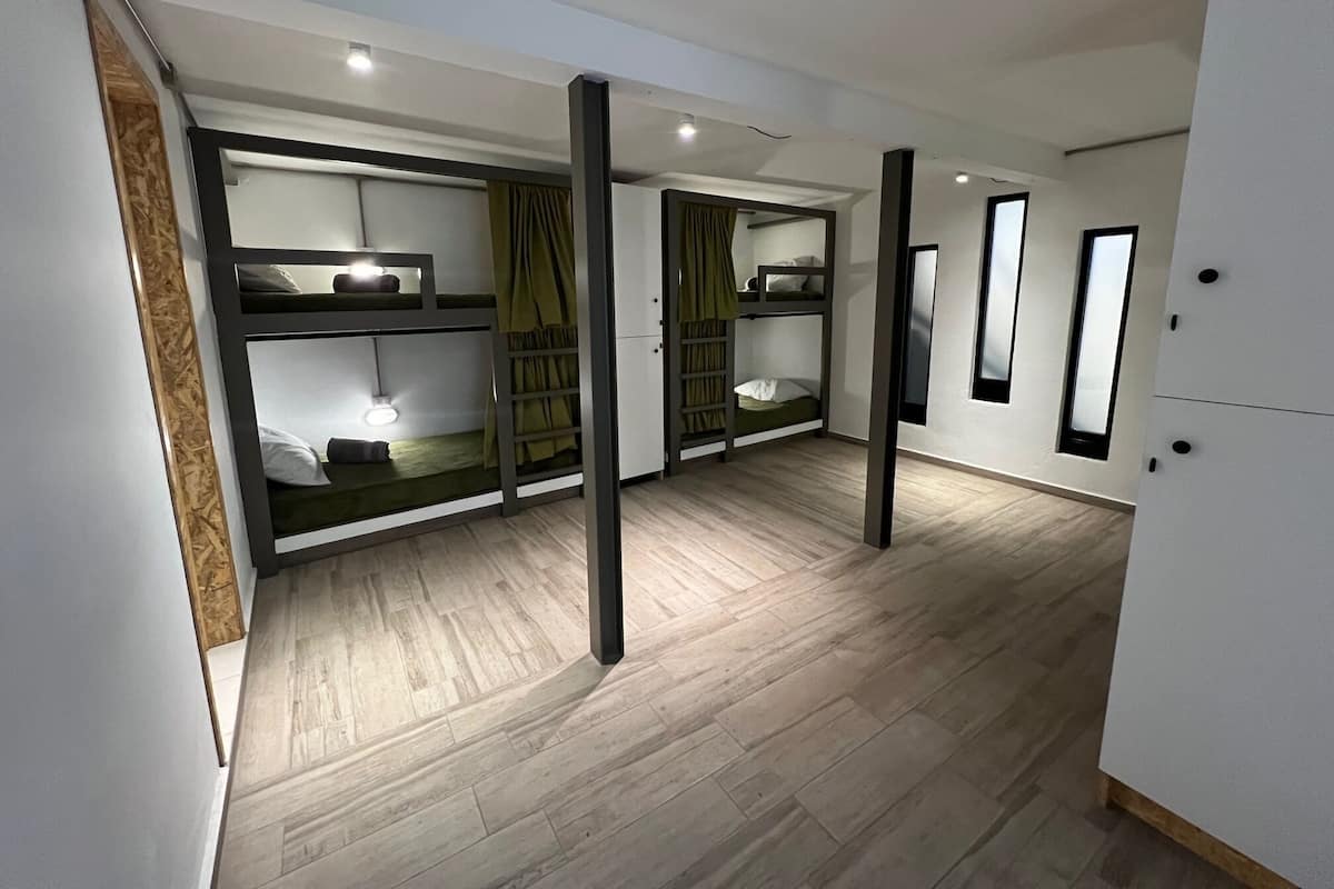 A modern hotel room with bunk beds, a wardrobe, and a mirror.