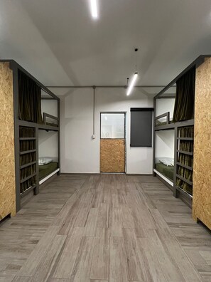 A room with bunk beds, a window, and a door. - NOMADIK HOSTEL (Puebla)