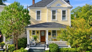 A two-story house with a front porch, a chimney, and a well-maintained garden. - Historic Gem King Ste Walk to Downtown Riverwalk & Wedding Venues (Wilmington)