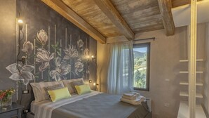 Une chambre avec un grand lit, une fresque murale, une fenêtre avec des rideaux et un plafond en bois.