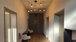 Ein modernes Interieur mit Essbereich, Holzboden und einer Chandelier.