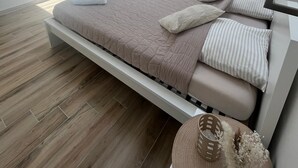Ein modernes Schlafzimmer mit einem Bett, einem Kleiderschrank und einem Flachbildfernseher.