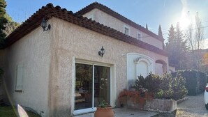 A house with a tiled roof, a sliding glass door, and a large potted plant in the front yard. - Maison provençale de Cabriès - 20min de Marseille (Cabriès)