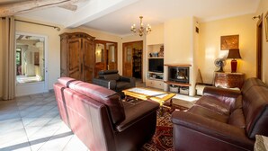 A spacious living room with leather sofas, a wooden cabinet, and a television. - Maison provençale de Cabriès - 20min de Marseille (Cabriès)