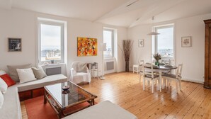 En rummelig stue med sofa, sofabord og spiseplads.