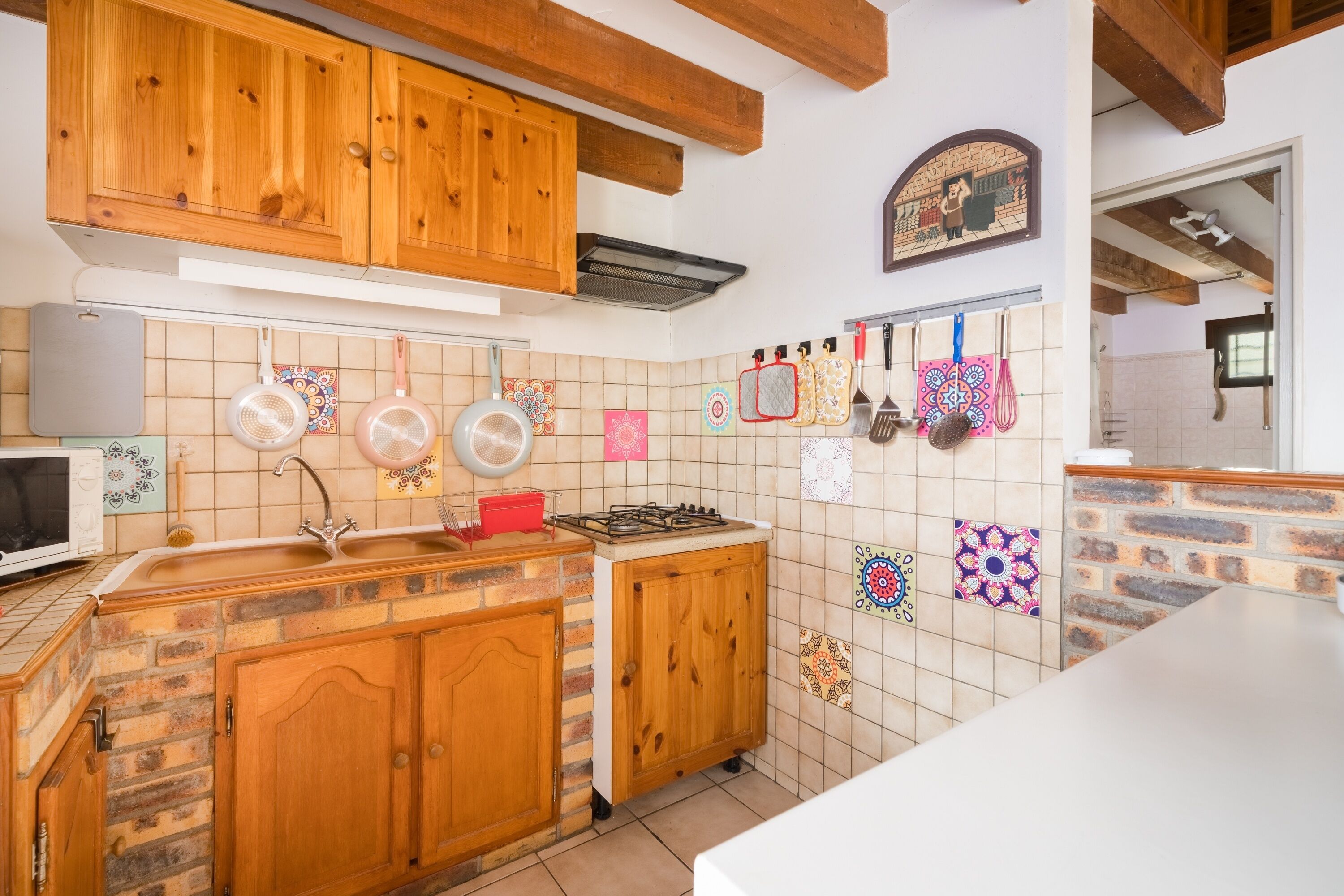 A kitchen with wooden cabinets, a stove, and a tiled backsplash.