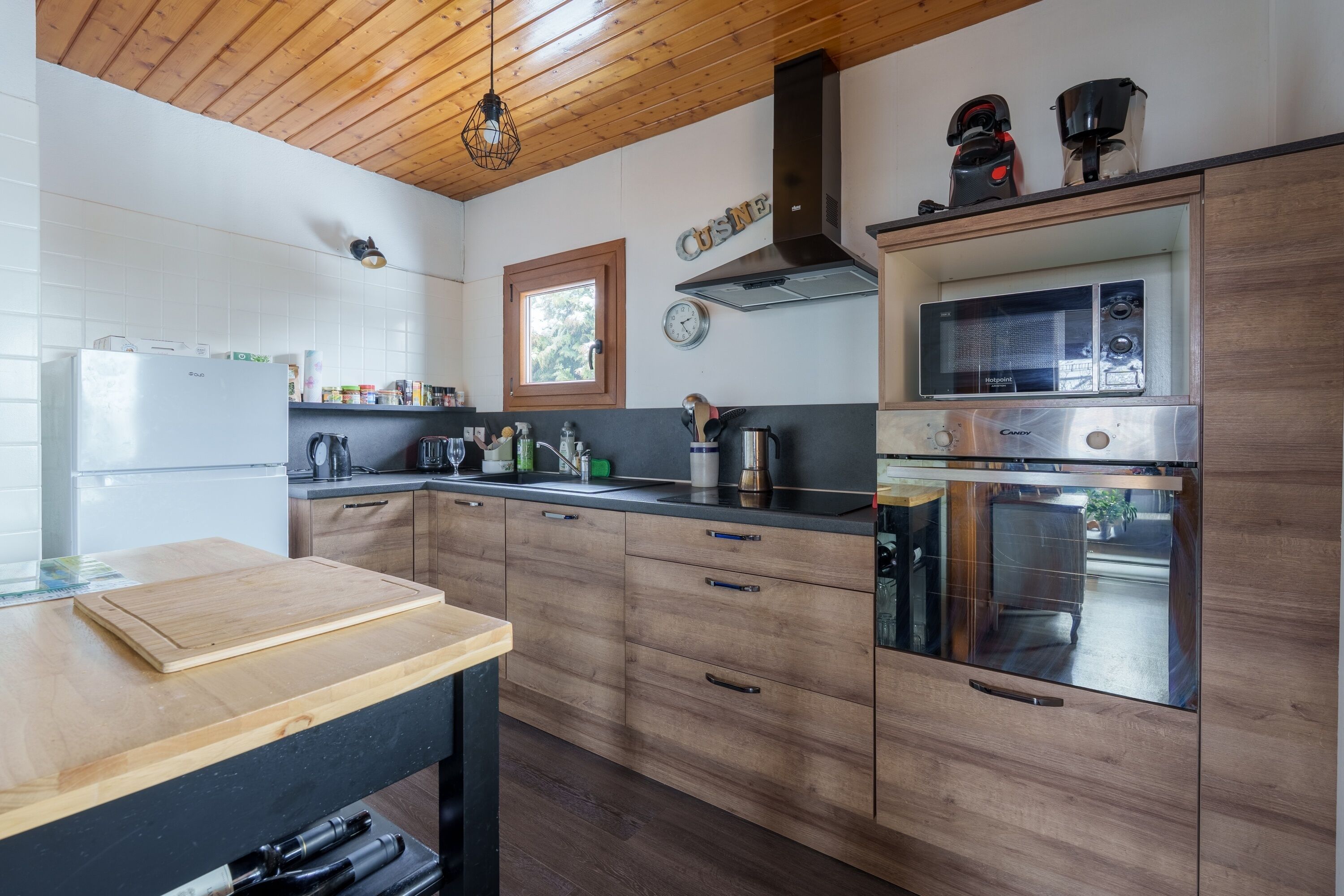 Een moderne keuken met houten kastjes, een roestvrijstalen oven en een houten aanrecht.