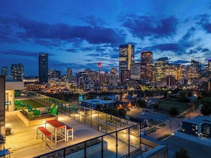 Une terrasse sur le toit offrant une vue sur les toits d’une ville au crépuscule.