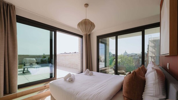 A hotel room with a large bed, two windows, and a view of the city. - Large apartment with balcony, 3 BR and 2 Bathrooms (Antwerpen)