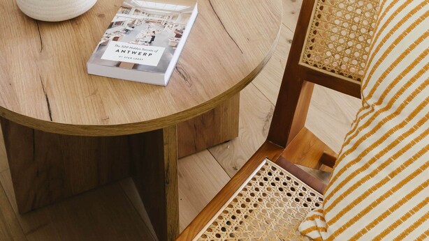 Un tavolo rotondo in legno con una lampada bianca e un libro intitolato "The 500 Hidden Secrets of Antwerp".