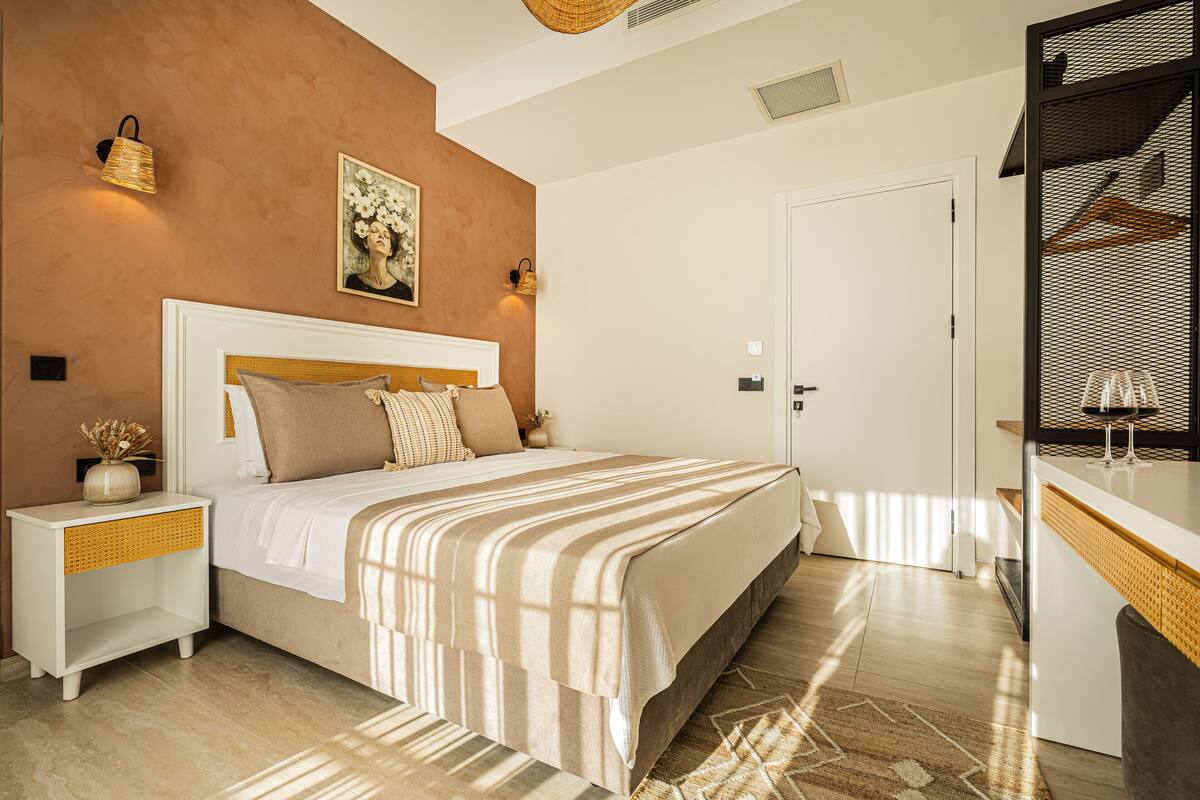 A modern bedroom with a large bed, bedside tables, a wardrobe, and a mirror.
