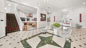 Eine moderne Hotelhalle mit Treppe, Essbereich und Rezeption.