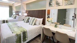 Ein Hotelzimmer mit Bett, Nachttisch, Stuhl, Schreibtisch und Spiegel.