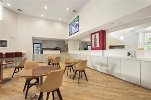 Een modern restaurant met houten vloeren, ronde tafels en stoelen.