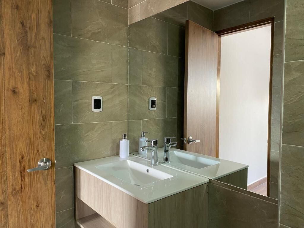 Une salle de bain avec deux lavabos, des meubles en bois et un miroir.