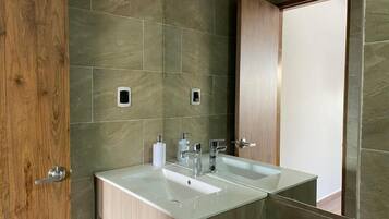 A bathroom with two sinks, wooden cabinetry, and a mirror.