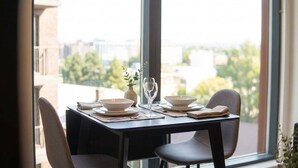 Mesa para dos personas con vista a un paisaje urbano a través de grandes ventanales.