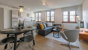 Una sala de estar moderna con una mesa de comedor, sofá y sillas.