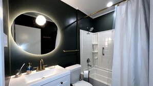 Een moderne badkamer met een wit wastafel, toilet en bad.