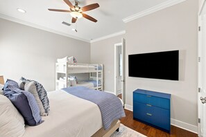 A bedroom with a bed, bunk beds, a ceiling fan, a TV, and a blue dresser. - Newly Furnished | LSV | Community Pool (Santa Rosa Beach)