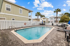 A swimming pool with a white fence, lounge chairs, and a palm tree. - Newly Furnished | LSV | Community Pool (Santa Rosa Beach)