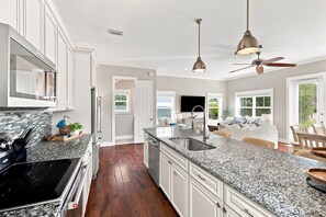 A kitchen with granite countertops, stainless steel appliances, and a large island with a sink. - Newly Furnished | LSV | Community Pool (Santa Rosa Beach)