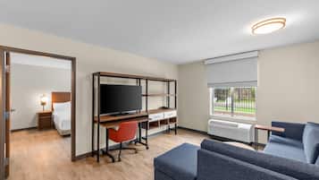 Une chambre d’hôtel moderne équipée d’un lit, d’un bureau, d’une télévision et d’un coin salon.