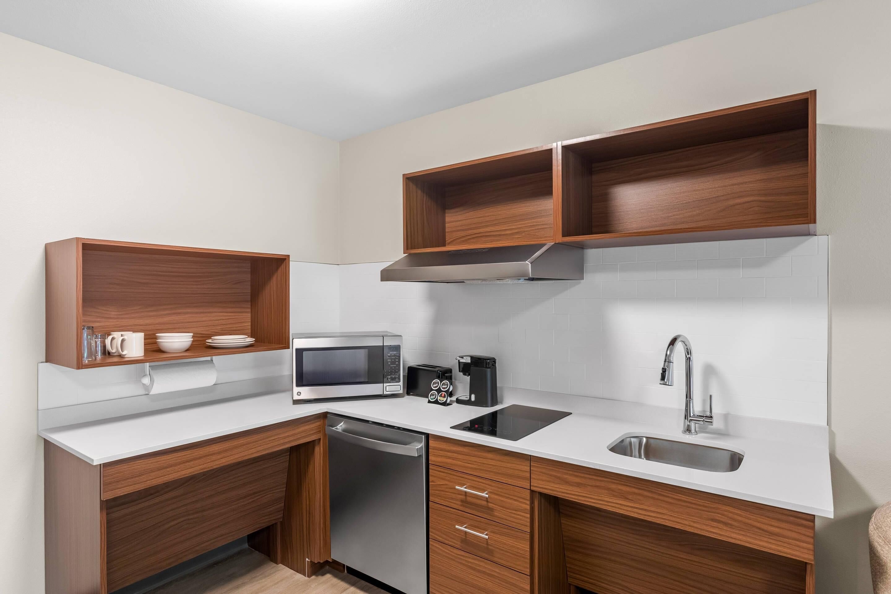 A compact kitchen with a microwave, coffee maker, and a dishwasher.