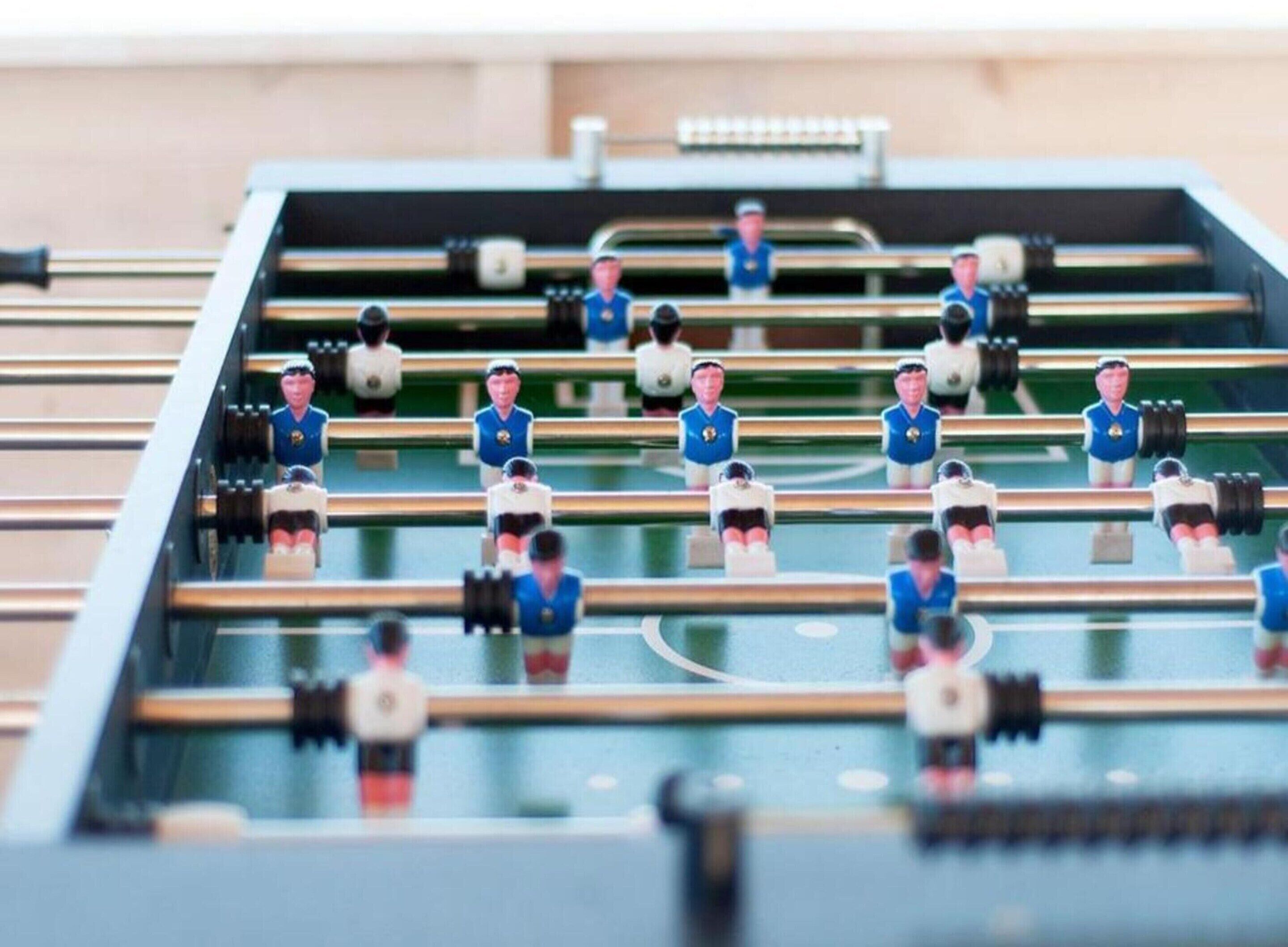 Une table de baby-foot avec des joueurs portant des uniformes.