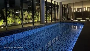 An indoor swimming pool with a tiled floor, glass walls, and a view of greenery outside. - Luxo na Faria Lima - Millenium (São Paulo)