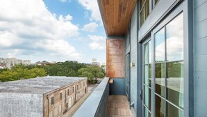 A modern building with large windows and a wooden overhang. - The Windrose (Savannah)