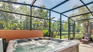 Un bain à remous situé dans un espace extérieur abrité, avec vue sur un jardin et des arbres.