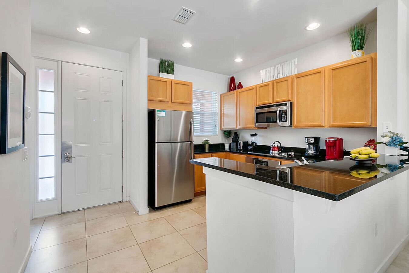 A modern kitchen with wooden cabinets, stainless steel appliances, and a central island.