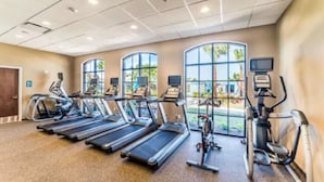 Ein Fitnessstudio mit Laufbändern, Crosstrainern und stationären Fahrrädern.