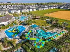 A water park with multiple slides and pools, surrounded by residential buildings. - #1141 Two Resorts Waterside/Pool/Spa Disney Epic (Reunion)